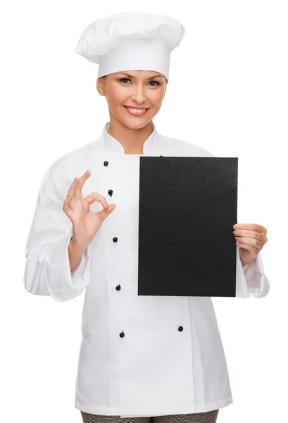 Chef feminino sorridente com papel em branco preto — Fotografia de Stock