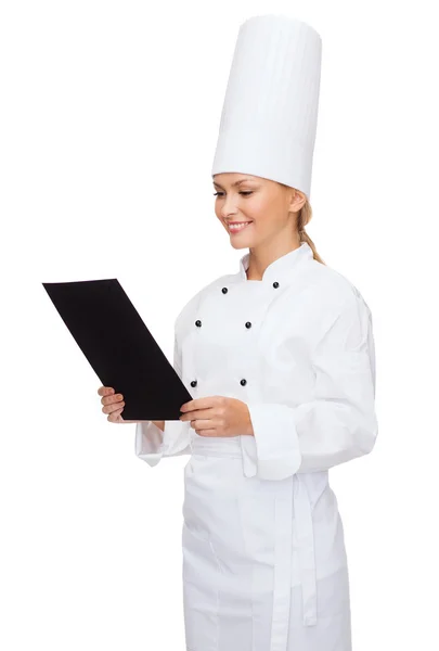 Chef feminino sorridente com papel em branco preto — Fotografia de Stock