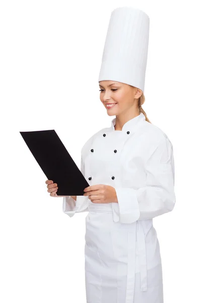 Smiling female chef with black blank paper — Stock Photo, Image