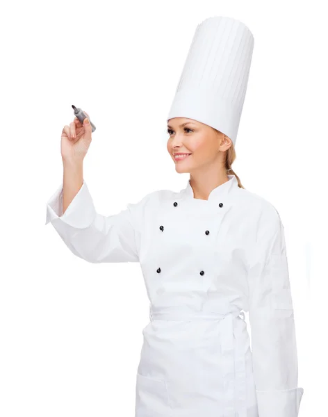 Smiling female chef writing something on air — Stock Photo, Image