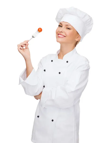 Chef feminino sorridente com garfo e tomate — Fotografia de Stock