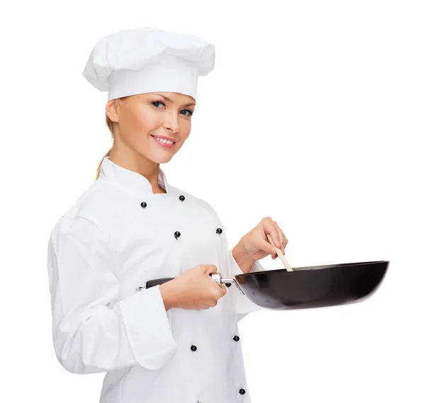 Chef feminino sorridente com panela e colher — Fotografia de Stock