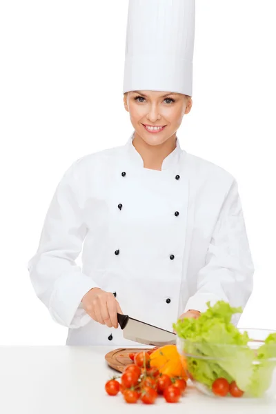 Sorrindo chef feminino cortando vagetáveis — Fotografia de Stock