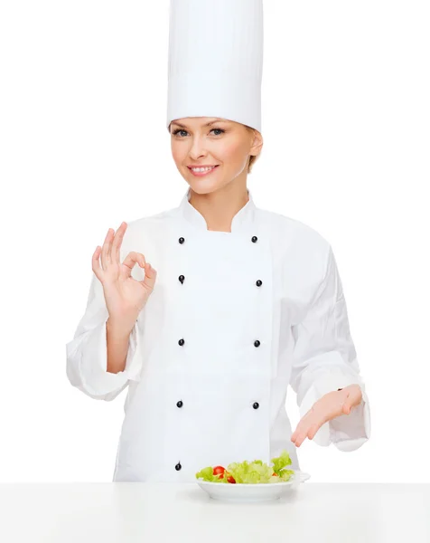 Chef feminino sorridente com salada no prato — Fotografia de Stock