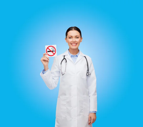 Glimlachend vrouwelijke arts houden geen rookvrije teken — Stockfoto