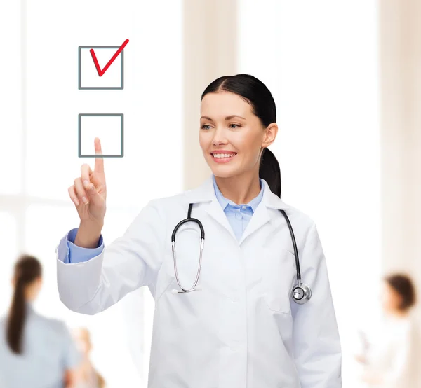 Sorrindo médico feminino apontando caixa de seleção — Fotografia de Stock