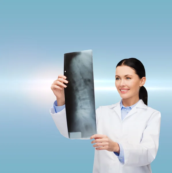 Souriant médecin féminin regardant la radiographie — Photo