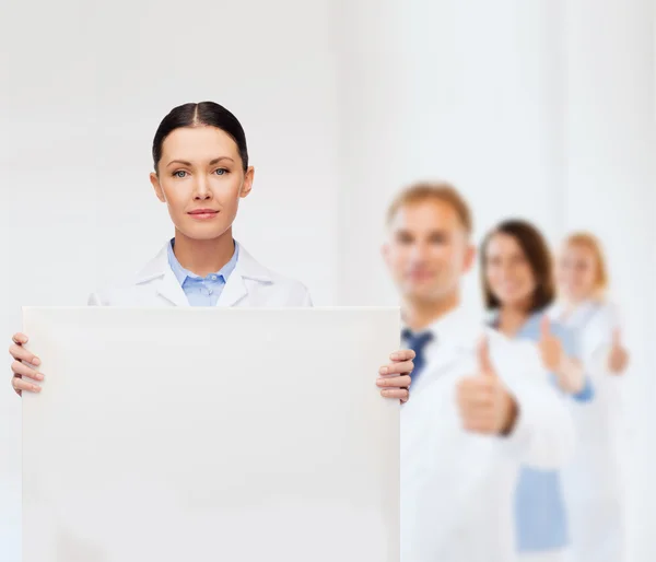 Kalm vrouwelijke arts met wit leeg bord — Stockfoto