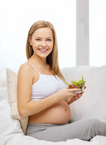 Happy pregnant woman with bowl of salad — Stock Photo, Image