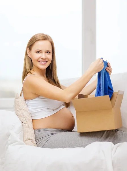 Lächelnde Schwangere öffnet Paketkasten — Stockfoto