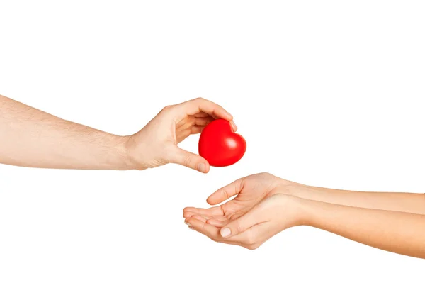 Mano de hombre dando corazón rojo a la mujer — Foto de Stock