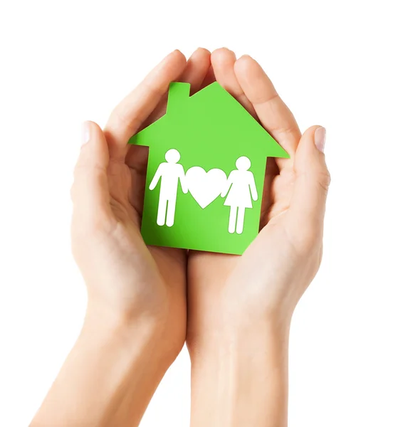 Hands holding green house with family — Stock Photo, Image