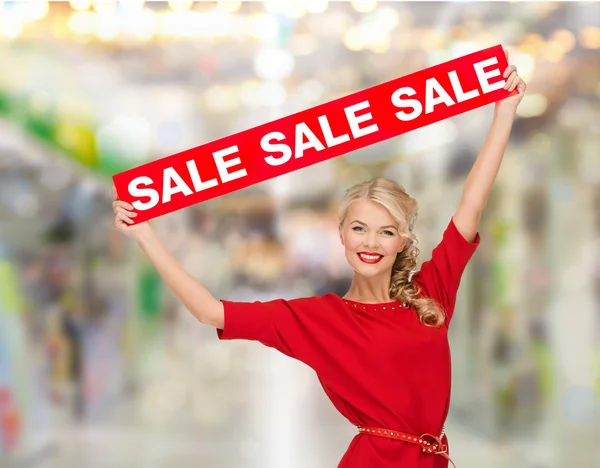 Mujer sonriente en vestido con signo de venta roja — Foto de Stock