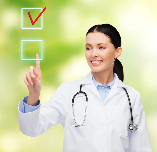 Sonriente doctora apuntando a la casilla de verificación — Foto de Stock