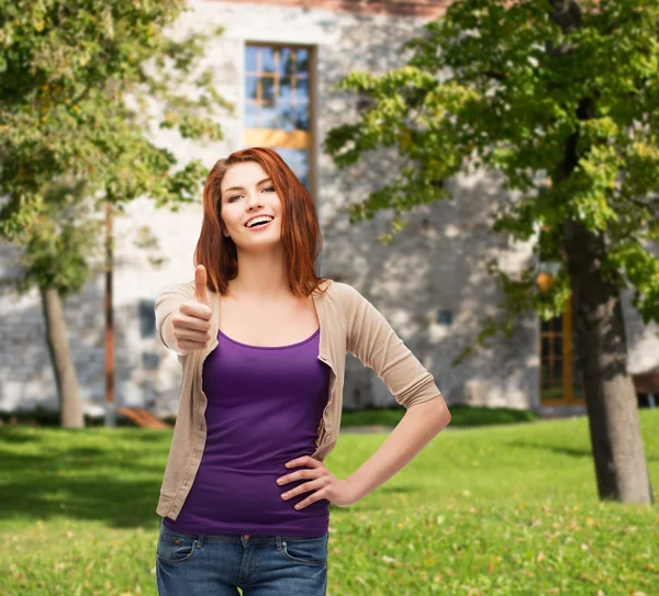 Sonriente chica en ropa casual mostrando los pulgares hacia arriba — Foto de Stock