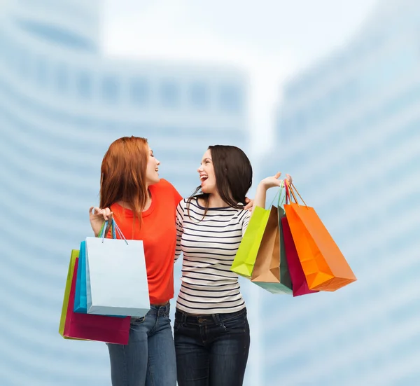 Two smiling teenage girls with shopping bags — Stock Photo, Image