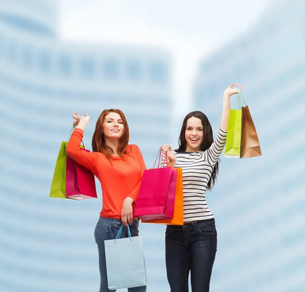 Twee glimlachend tienermeisjes met shopping tassen — Stockfoto