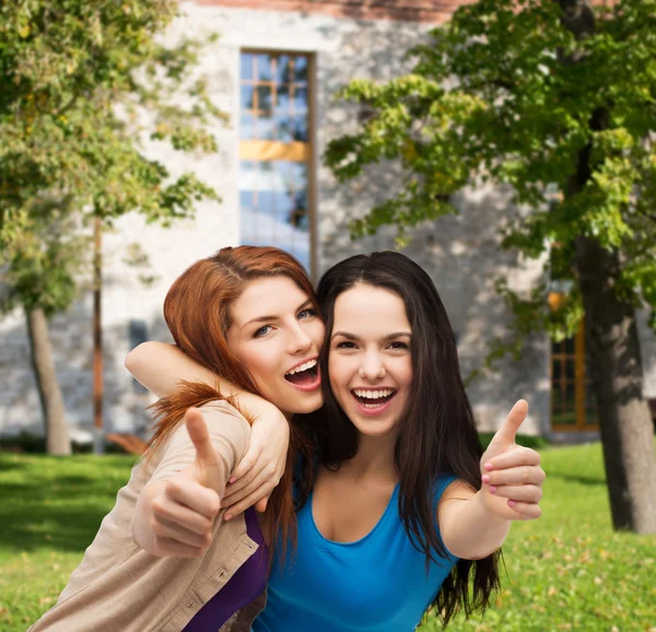 Dos chicas sonrientes mostrando los pulgares hacia arriba —  Fotos de Stock