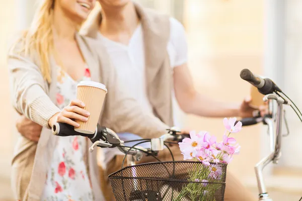 Casal segurando café e andar de bicicleta — Fotografia de Stock