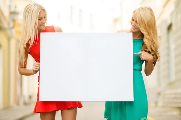 Dos mujeres rubias felices con pizarra blanca en blanco —  Fotos de Stock