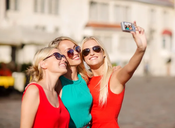 Três meninas bonitas tirando fotos na cidade — Fotografia de Stock