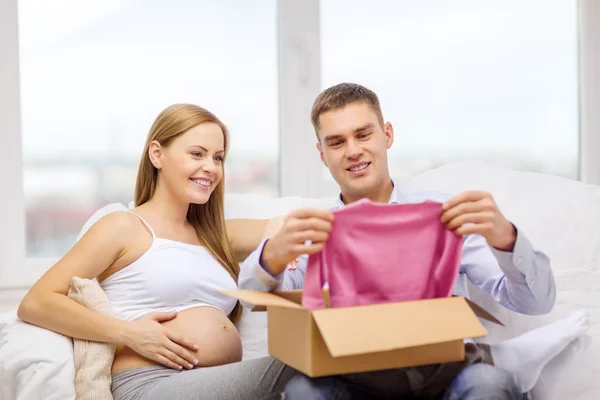 Familia feliz esperando que el niño abra la caja de paquetes — Foto de Stock