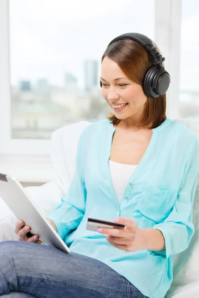 Mulher feliz com tablet pc e cartão de crédito em casa — Fotografia de Stock