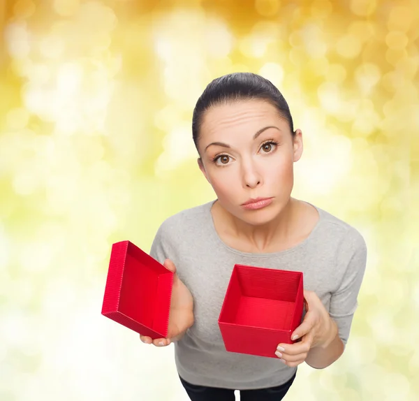 Enttäuschte asiatische Frau mit leerer roter Geschenkbox — Stockfoto