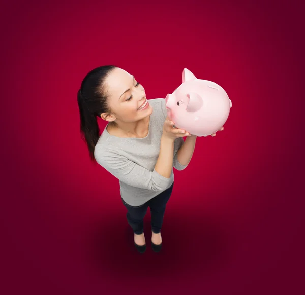 Happy woman looking at piggy bank — Stock Photo, Image