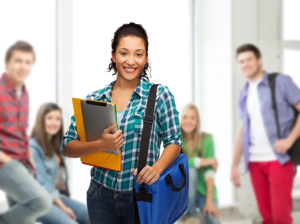 Lachende student met mappen, tablet pc en tas — Stockfoto