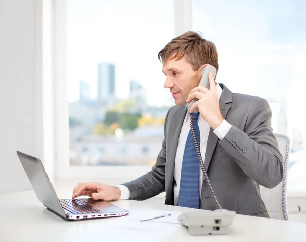 Empresario con ordenador portátil y teléfono —  Fotos de Stock