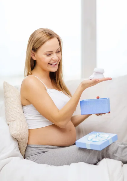 Femme enceinte souriante avec boîte cadeau et bottines — Photo