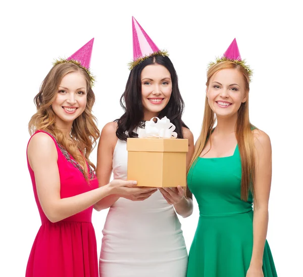 Три улыбающиеся женщины в синих шляпах с подарочной коробкой — стоковое фото