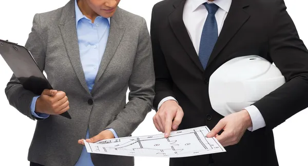 Businesspeople with blueprint and helmet — Stock Photo, Image