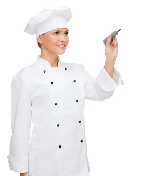 Sorrindo chef feminino escrevendo algo no ar — Fotografia de Stock