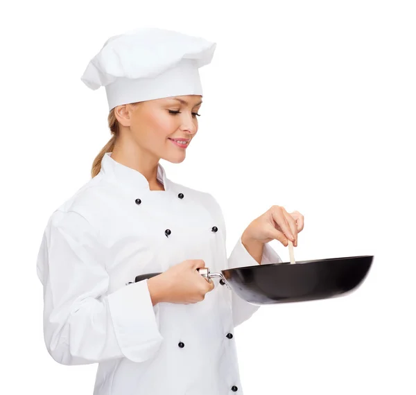 Uśmiechnięta kobieta kucharz z patelni i łyżka — Zdjęcie stockowe