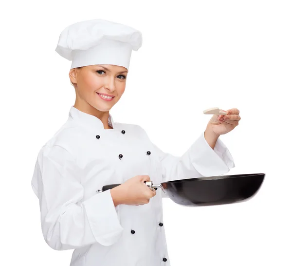 Chef féminin souriant avec casserole et cuillère — Photo
