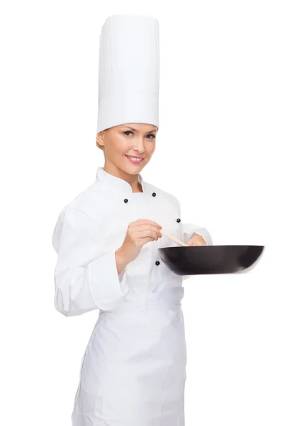 Chef feminino sorridente com panela e colher — Fotografia de Stock