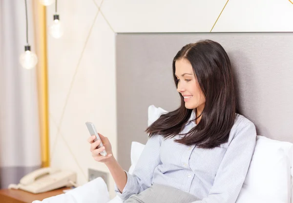 Empresária feliz com smartphone no quarto de hotel — Fotografia de Stock