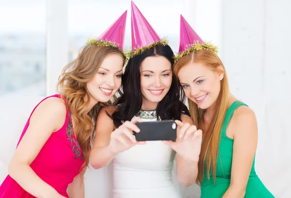 Three smiling women in hats having fun with camera Royalty Free Stock Photos