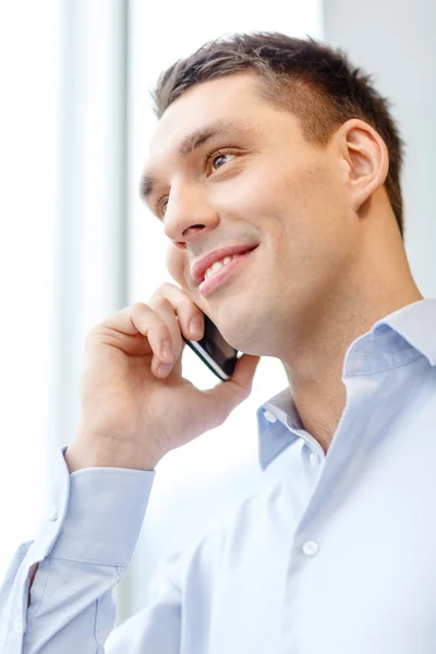 Empresário sorridente com smartphone no escritório — Fotografia de Stock