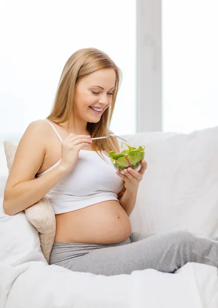 Happy pregnant woman eating salad — Stock Photo, Image