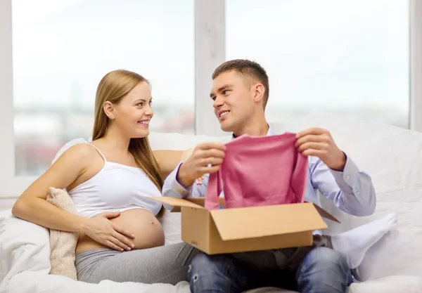 Família feliz esperando criança caixa de pacote de abertura — Fotografia de Stock