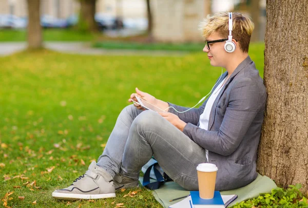 Jongen met koptelefoon, tablet pc, boeken en koffie — Stockfoto