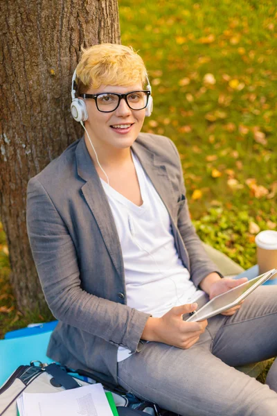 Estudante do sexo masculino sorridente em óculos com tablet pc — Fotografia de Stock