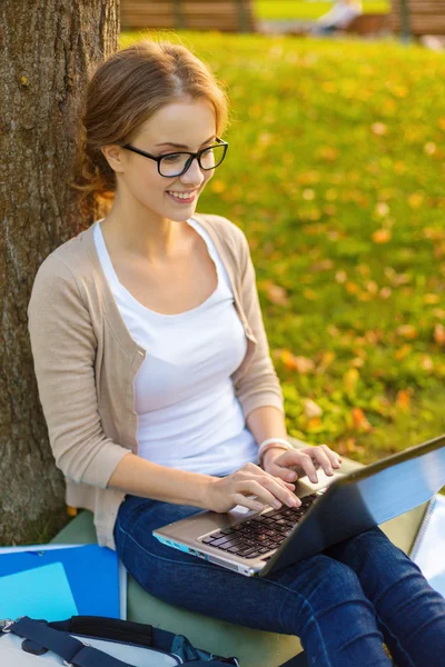 Adolescente sorridente in occhiali con laptop — Foto Stock