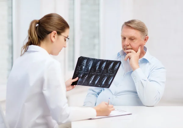 Médecin féminin avec vieil homme regardant les rayons X — Photo