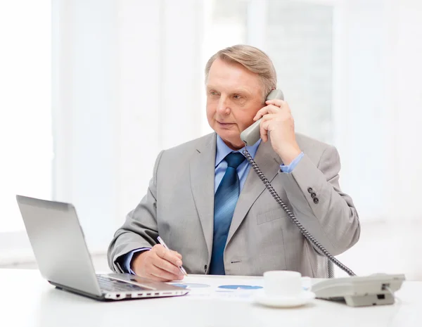 Empresário mais velho ocupado com laptop e telefone — Fotografia de Stock