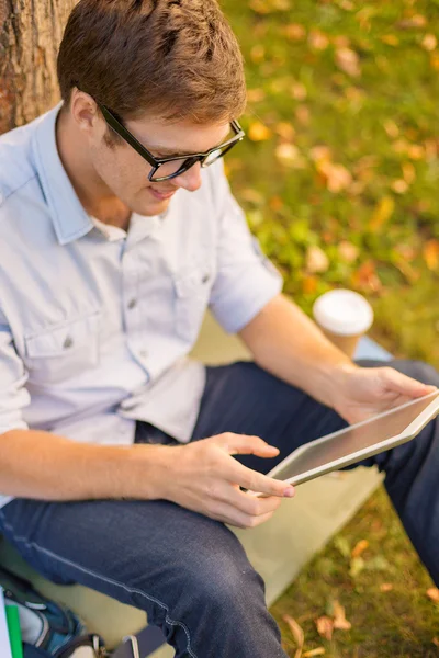 Estudiante masculino sonriente en anteojos con tableta pc —  Fotos de Stock