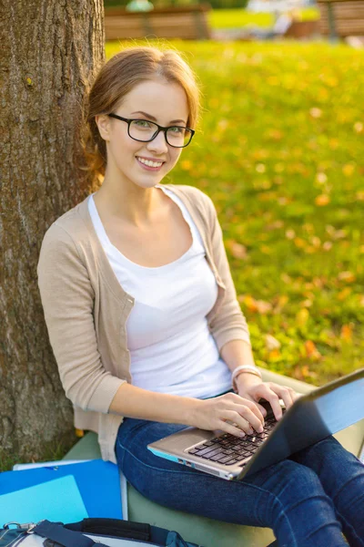 Smiling teenager in eyeglasses with laptop Royalty Free Stock Images